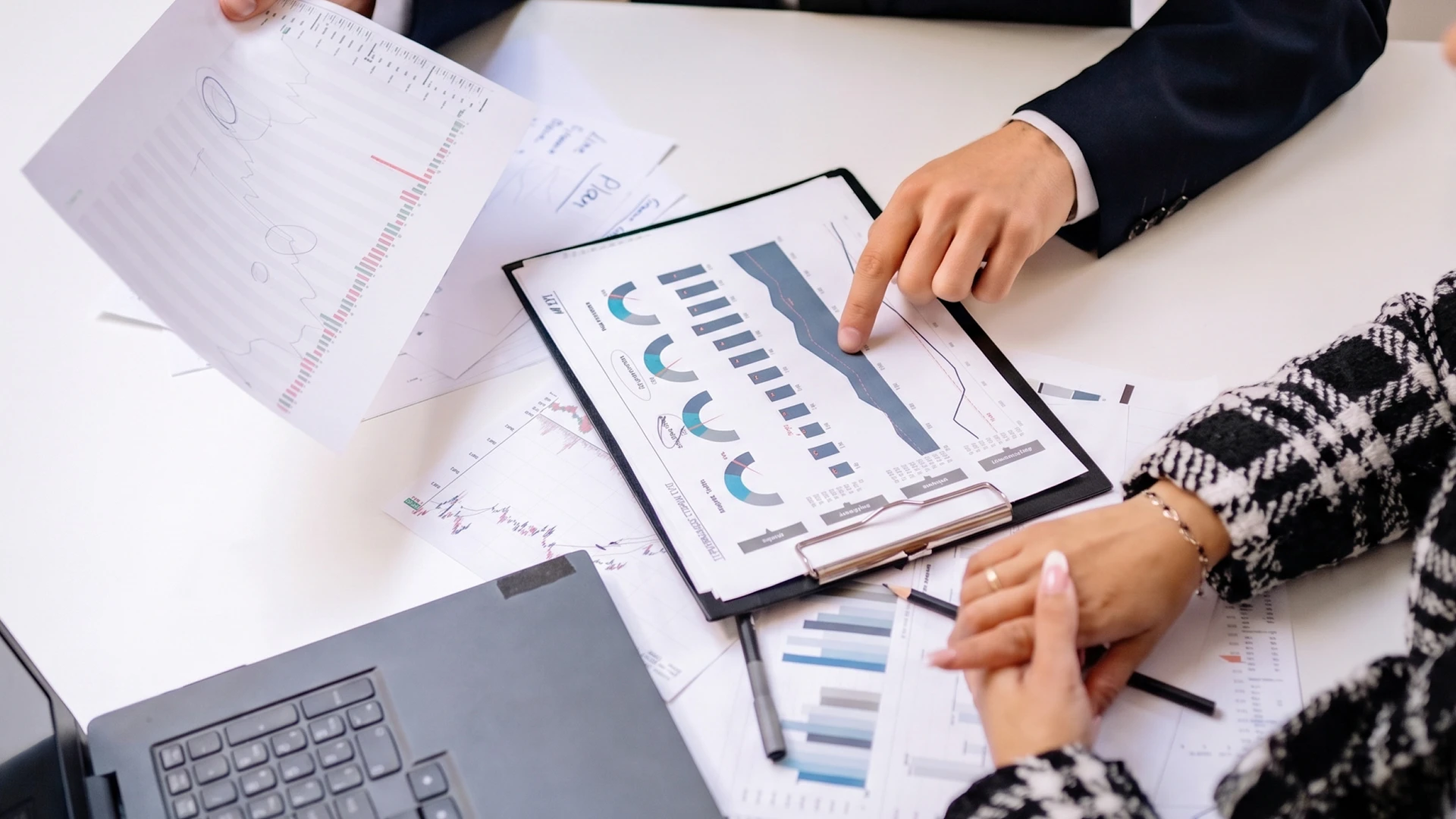 Personne travaillant sur ordinateur portable dans bureau moderne, consultant tableau de bord analytique avec graphiques, indicateurs de performance et données statistiques