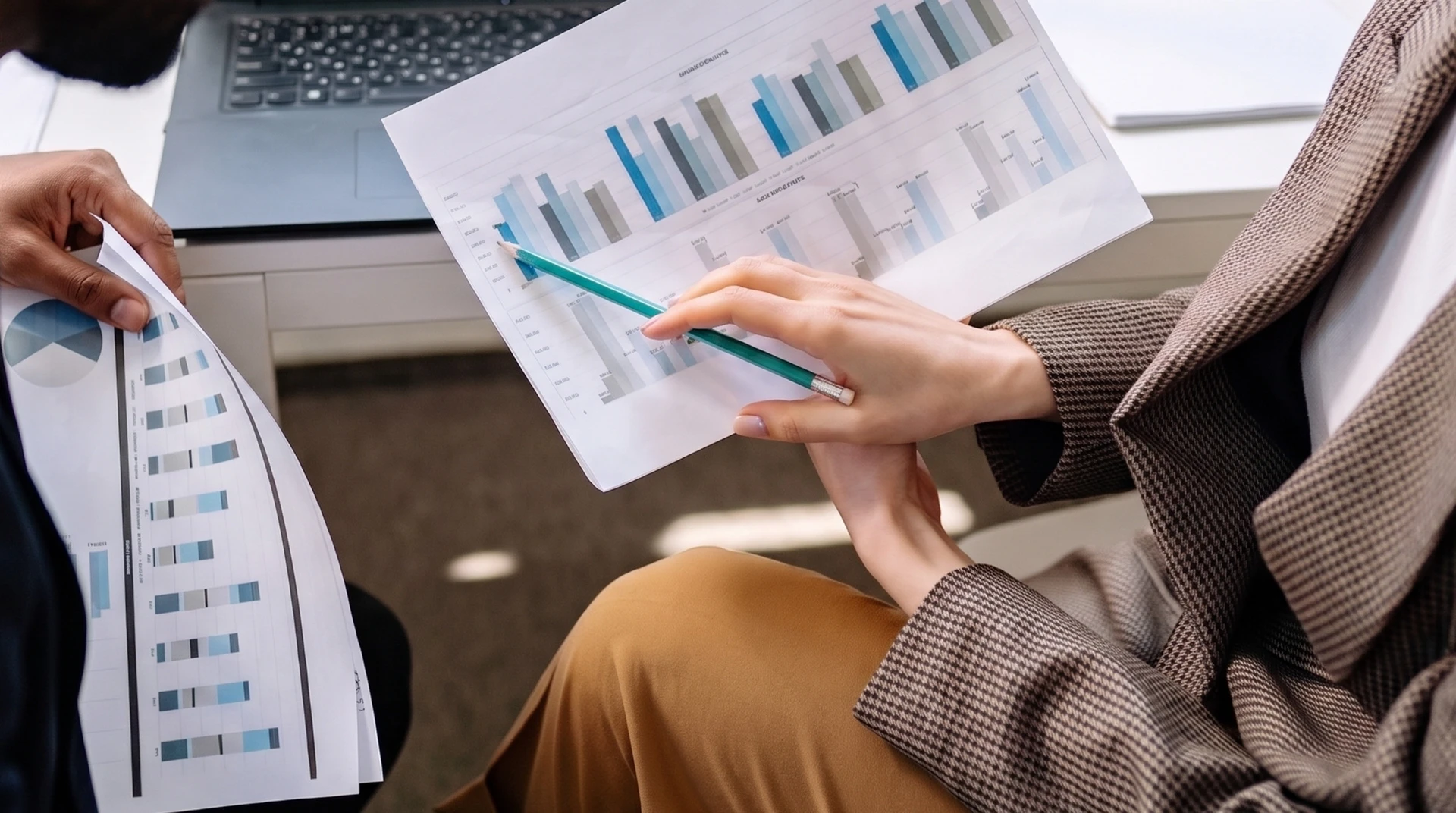 Personne travaillant sur ordinateur portable dans bureau moderne, analysant tableaux de bord financiers avec graphiques et métriques