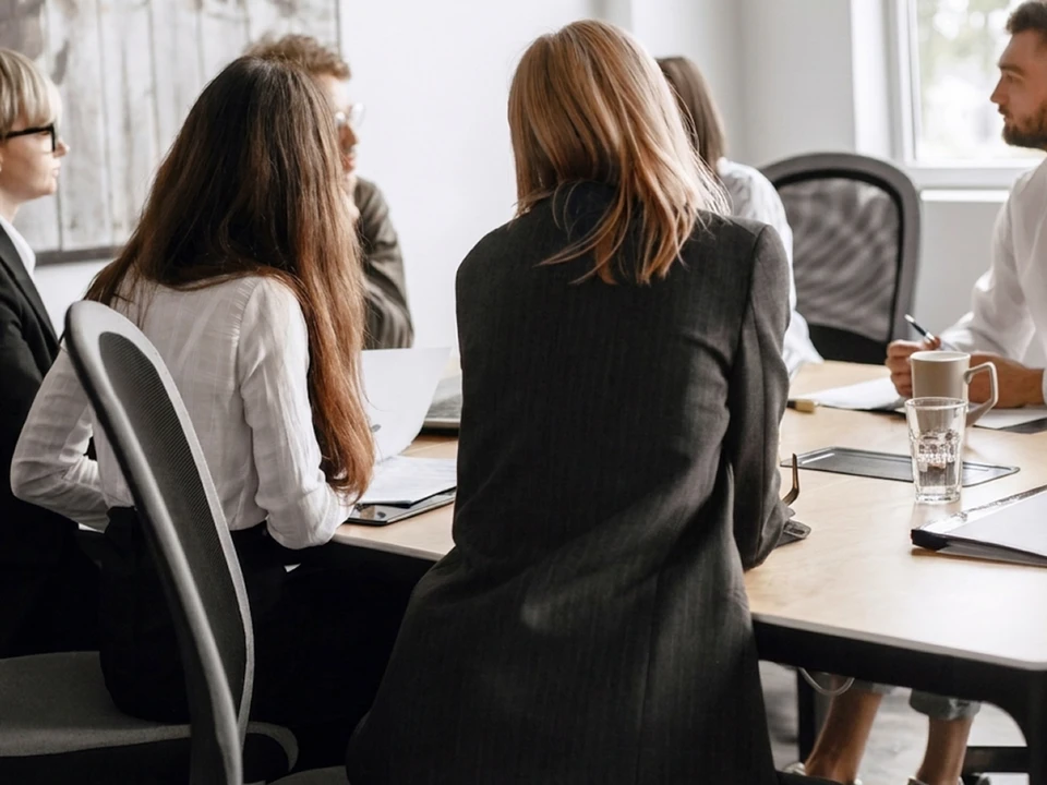 Réunion de travail en intérieur avec deux personnes analysant des tableaux de bord sur ordinateur portable